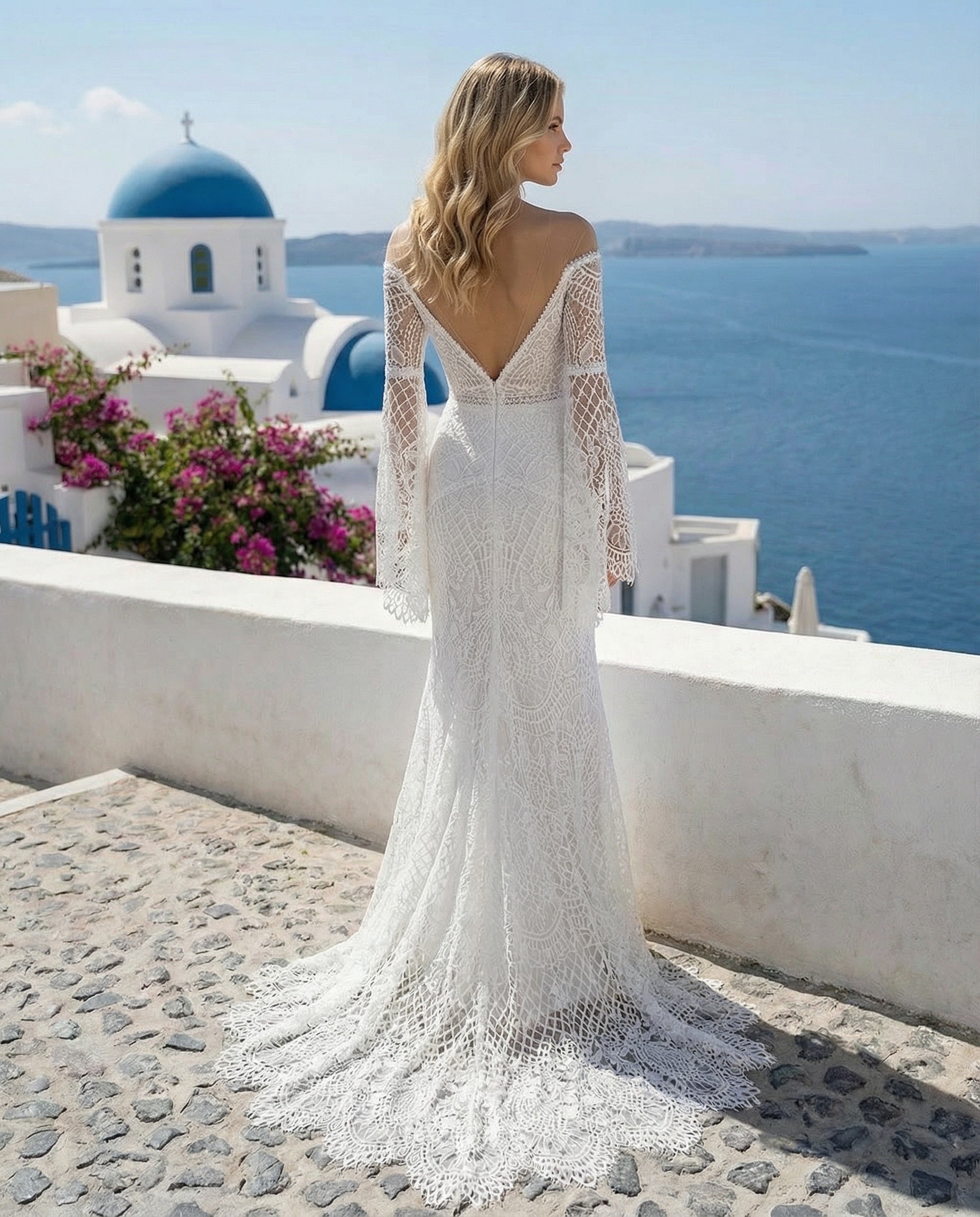 Robe de mariée fourreau en dentelle à épaules dénudées, décolleté en V et manches longues évasées, ornée d'épaules transparentes et de dentelle