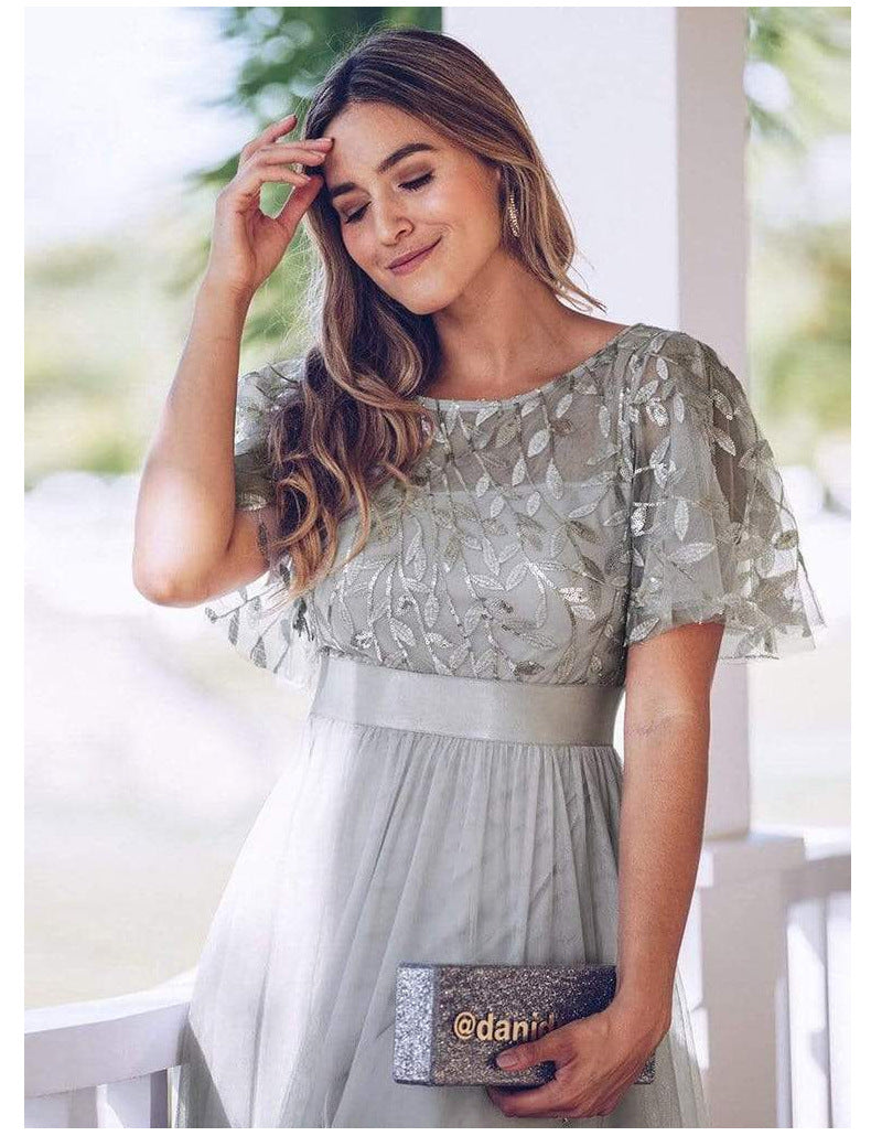 Krátké zvonové rukávy, výstřih do oblouku, korzet s flitry, áčková tylová večerní šaty s páskem