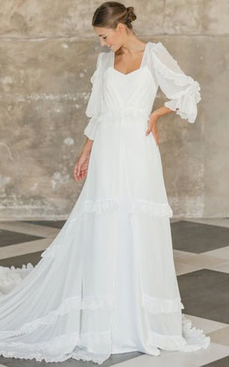 Robe de mariée fluide et éthérée en mousseline à manches longues avec traîne à plusieurs niveaux